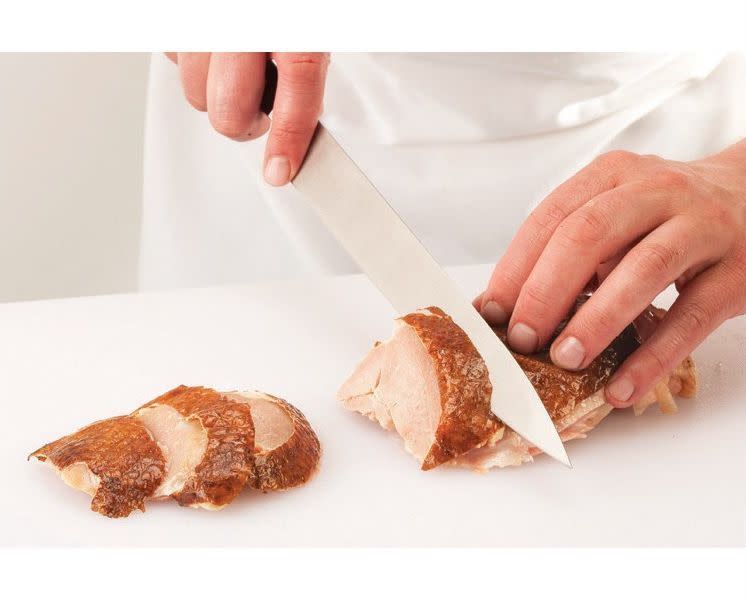 Flip the thigh so that it’s skin side up and bias-cut it into serving-size slices.