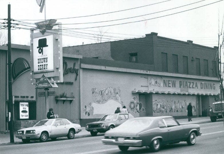 Akron motorists pass the Brown Derby restaurant at Highland Square in 1980.