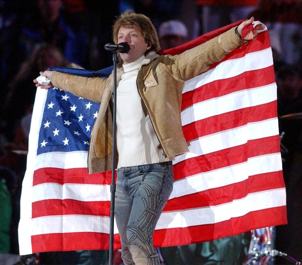 Jon Bon Jovi holds up an American flag as he performs during the Salt Lake 2002 Winter Games closing ceremony at the University of Utah’s Rice-Eccles Stadium on Sunday, Feb. 24, 2002. | Jeffrey D. Allred, Deseret News