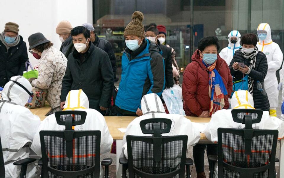 Medical workers help patients infected with coronavirus at a makeshift hospital in Wuhan, central China's Hubei Province. | Xinhua News Agency/Contributor