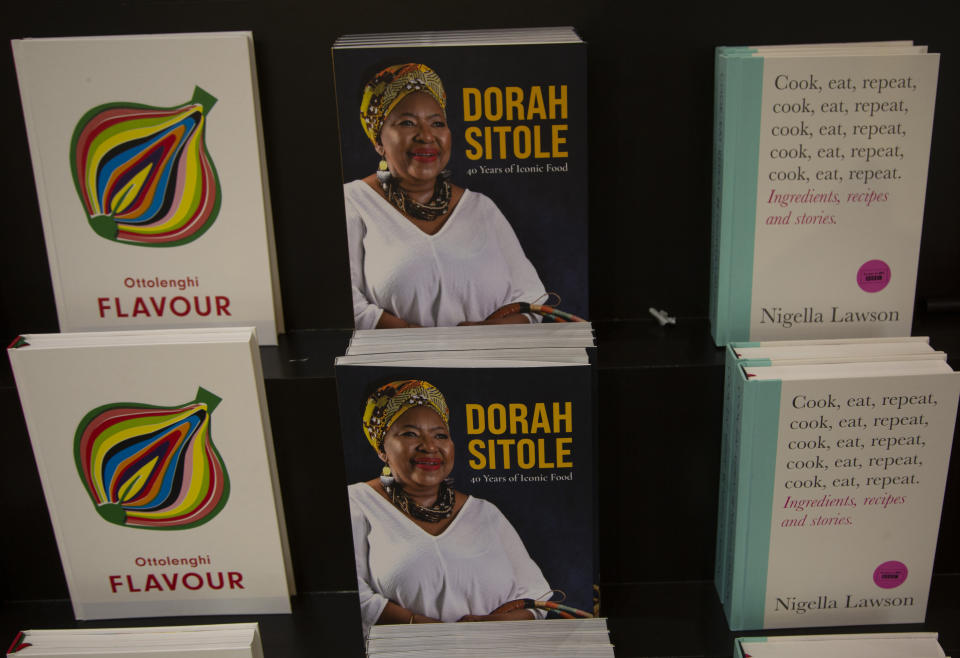 Copies of Dorah Sitole's cook book "40 Years of Iconic Food", seen at centre, in Exclusive Books in Hyde Park Corner, Johannesburg, Tuesday, Jan. 12, 2021. South Africa's pioneer Black food writer Sitole, portrait on cover, who quietly defied apartheid to win respect and a readership for African cuisine, died of COVID-19, in Jan. 2021. (AP Photo/Denis Farrell)