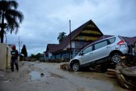 FILE PHOTO: A car is partially covered in mud after flash floods swept through Radda, North Luwu, South Sulawesi