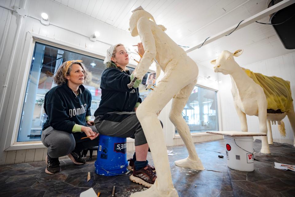 Hannah Pratt works on a butter sculpture of Caitlin Clark while her mother, Sarah Pratt, looks on.
