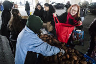 Philabundance volunteers distribute food to furloughed federal worker Linda Cheeseman, right, who is affected by the partial government shutdown, under Interstate 95 in Philadelphia, Wednesday, Jan. 23, 2019. (AP Photo/Matt Rourke)