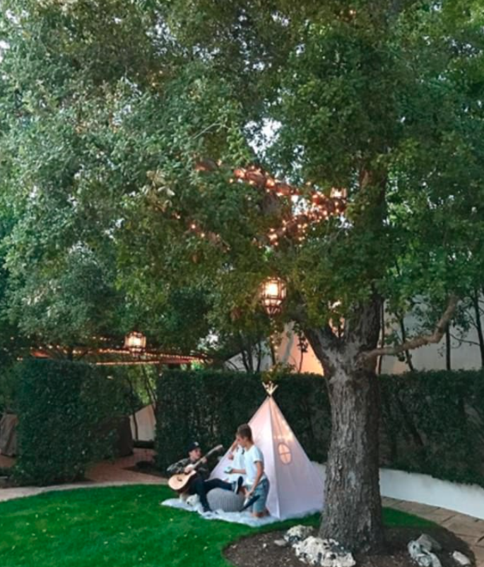 The kids enjoy chilling in the teepee decorated with fair lights while practicing guitar. Source: Instagram