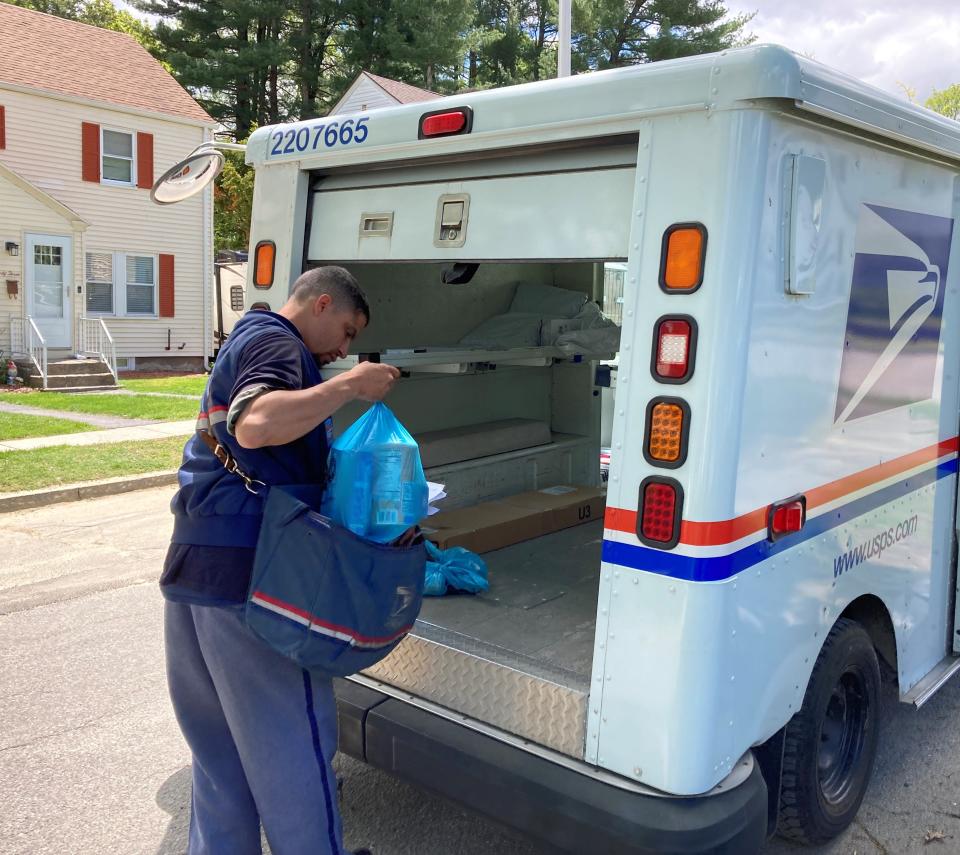 Mail carrier Marvin Gonzalez stashes the bag of groceries he picked up from a residence on Walworth Street in the back of his truck Saturday during the Stamp Out Hunger food drive.