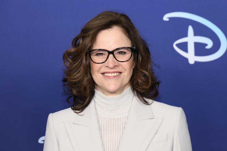 Ally Sheedy wears a turtleneck under a matching colored blazer