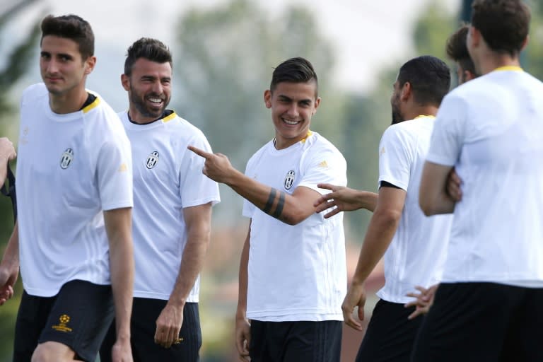 Juventus' Andrea Barzagli (2nd L) and Paulo Dybala (C) take part in a training session with teammates in Vinovo, near Turin, on April 18, 2017, on the eve of their UEFA Champions League quarter-final 2nd leg match against Barcelona