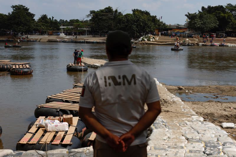 An immigration agent keeps watch at the banks of the Suchiate river, the natural border between Mexico and Guatemala, to guard the border and prevent a migrant caravan of Central Americans from entering, in Ciudad Hidalgo