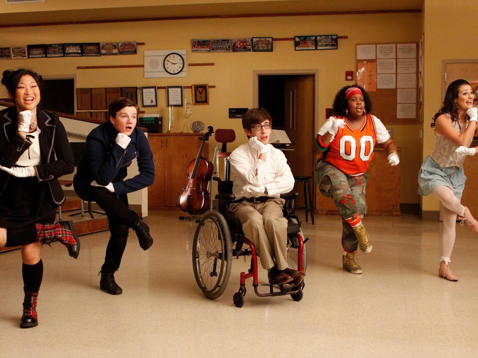 The cast of glee dancing in season one choir room