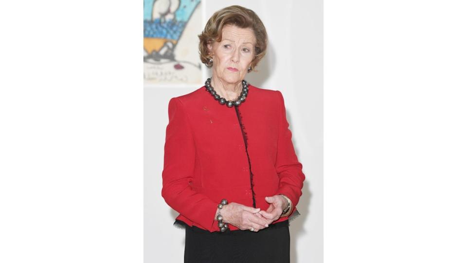 Queen Sonja in a red outfit and pearl necklace