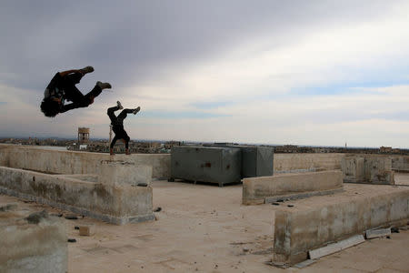 Parkour coach Ibrahim al-Kadiri, 19, demonstrates his Parkour skills with his friend in the rebel-held city of Inkhil, west of Deraa, Syria, February 4, 2017. REUTERS/Alaa Al-Faqir