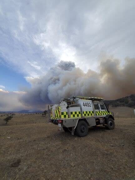 This image released Thursday, Jan. 2, 2020, from the Department of Environment, Land, Water and Planning in Gippsland, Australia, shows an emergency vehicle in front of massive smoke rising from wildfires burning in East Gippsland, Victoria. Thousands of tourists are fleeing Australia's wildfire-ravaged eastern coast ahead of worsening conditions as the military started to evacuate people trapped on the shore further south. Cooler weather has aided firefighting and allowed people to replenish supplies. (DELWP Gippsland via AP)