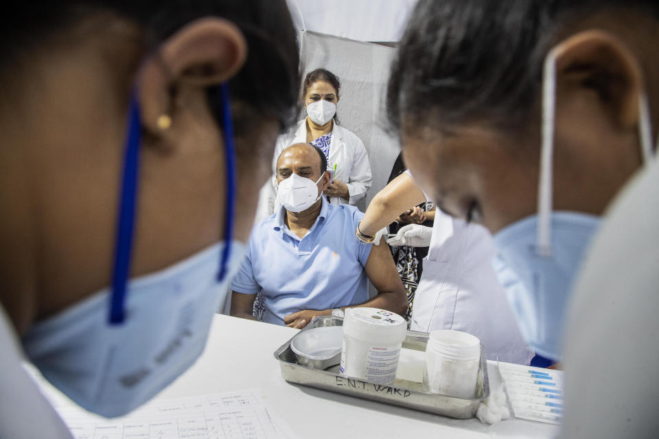 A health worker administers COVISHIELD vaccine to a man at the Guwahati Medical College hospital in Gauhati, India, Monday, March 1, 2021. India is expanding its COVID-19 vaccination drive beyond health care and front-line workers, offering the shots to older people and those with medical conditions that put them at risk. (AP Photo/Anupam Nath)