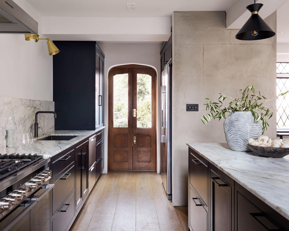 Galley kitchen with wood cabinets and marble countertop