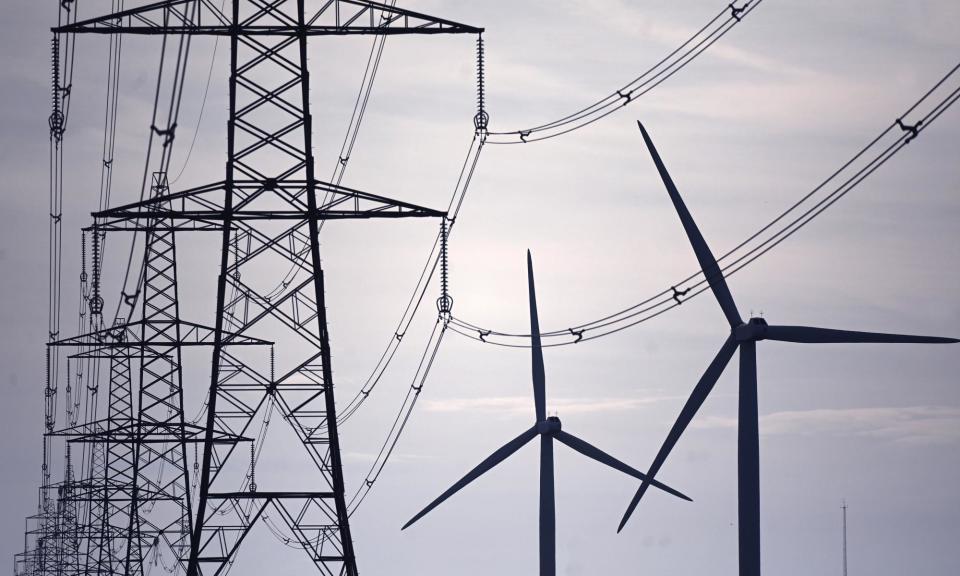 <span>Wind turbines and electricity pylons in Kent: five times more infrastructure will be needed by 2030 than has been built in the past three decades.</span><span>Photograph: Neil Hall/EPA</span>