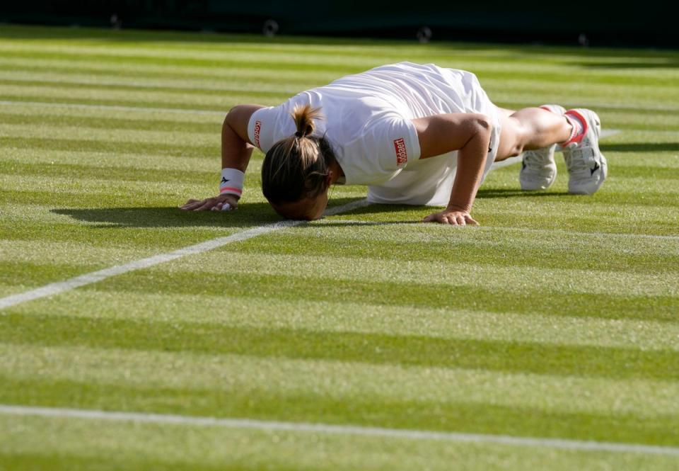 Kirsten Flipkens kisses the grass on Court Two at the end of her second round match with Simona Halep, which marked the end of her professional singles career (Alastair Grant/AP/PA) (AP)