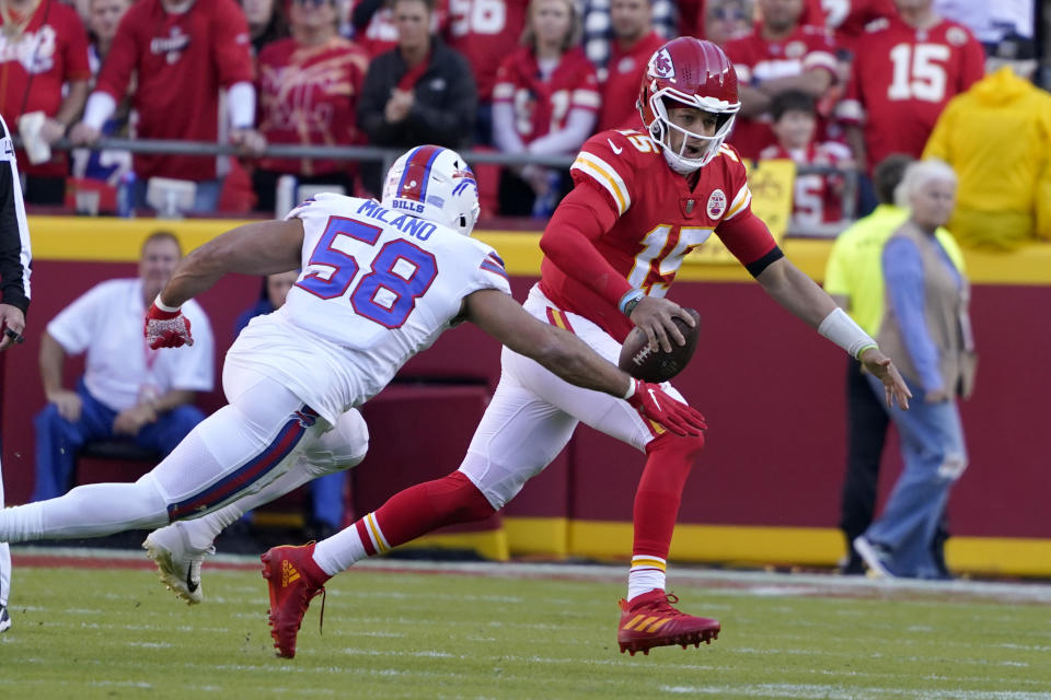 Kansas City Chiefs quarterback Patrick Mahomes (15) scrambles away from Buffalo Bills linebacker Matt Milano (58) during the first half of an NFL football game Sunday, Oct. 16, 2022, in Kansas City, Mo. (AP Photo/Ed Zurga)