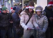 People line up and read the sales flyer outside a Toys"R"Us store in Times Square before their Black Friday Sale in New York November 28, 2013. REUTERS/Carlo Allegri