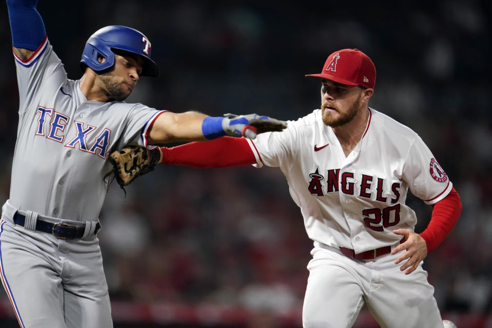Los Angeles Angels first baseman Jared Walsh, right, tags out Texas Rangers' Jason Martin along the first base line after a ground ball during the seventh inning of a baseball game Monday, Sept. 6, 2021, in Anaheim, Calif. (AP Photo/Marcio Jose Sanchez)