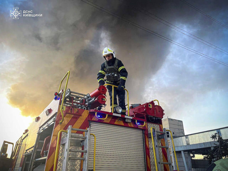 In this photo provided by the Ukrainian Emergency Service, an emergency worker extinguishes a fire after a Russian attack on the Trypilska thermal power plant in Ukrainka, Kyiv region, Ukraine, Thursday, April 11, 2024. (Ukrainian Emergency Service via AP)