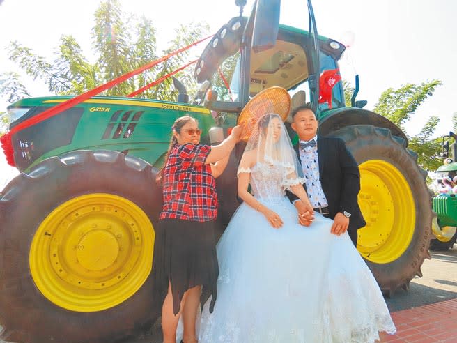 台南學甲區青農劉震鋐（右）以農用曳引車當結婚禮車，迎娶太太吳詩涵（中）。（莊曜聰攝）