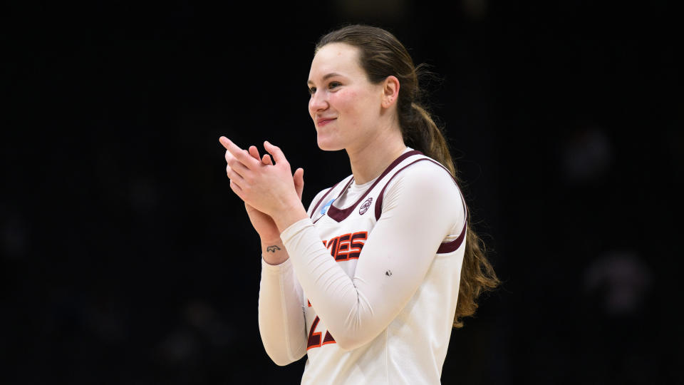 Virginia Tech guard Cayla King applauds the school's marching band as she exits the court after a victory against Tennessee in a Sweet 16 college basketball game of the NCAA Tournament in Seattle, Saturday, March 25, 2023. Virginia Tech won 73-64. (AP Photo/Caean Couto)