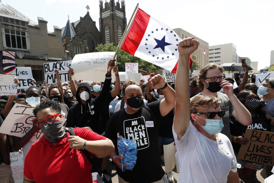 In this June 6, 2020 photograph, a "Stennis Flag" is waved by protesters gathered at a rally and march in downtown Jackson, Miss., in response to police brutality nationwide including Mississippi. The flag is often suggested as a possible replacement to the current flag that has in the canton portion of the flag the design of the Civil War-era Confederate battle flag. (AP Photo/Rogelio V. Solis)