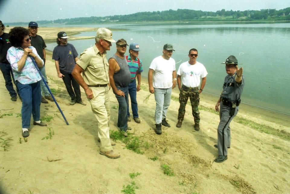 Kentucky State Trooper Trooper Larry Abel tells volunteers where Heather Teague was last seen across from Newburgh Beach as a search for the missing woman was renewed yesterday. Photograph by John Dunham that ran in the Sept. 8, 1995 edition of The Evansville Press.
