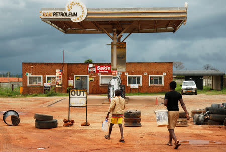 Children walk past a petrol station closed after protests in Harare, Zimbabwe, January 15, 2019. REUTERS/Philimon Bulawayo