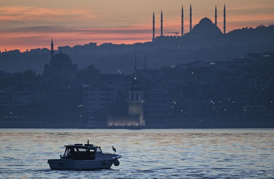 ISTANBUL, TURKIYE - APRIL 15: A fishing vessel glides through the Bosphorus as a stork is seen perching on the fishing vessel whilst the Maiden's Tower, Camlica and Suleymaniye Mosques are seen behind at early hours of morning in Istanbul, Turkiye on April 15, 2024. (Photo by Murat Sengul/Anadolu via Getty Images)