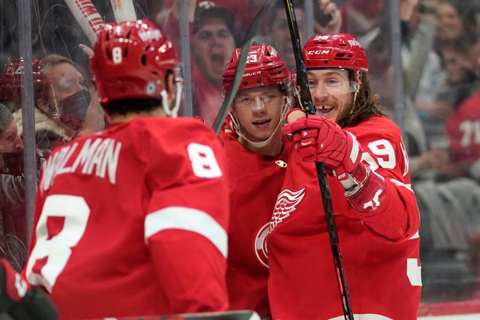 Detroit Red Wings left wing Lucas Raymond, center, celebrates his goal with Jake Walman (8) and Tyler Bertuzzi (59) against the Ottawa Senators in the second period of an NHL hockey game Friday, April 1, 2022, in Detroit.