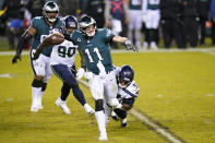 Philadelphia Eagles' Carson Wentz (11) is grabbed by Seattle Seahawks' Poona Ford (97) during the second half of an NFL football game, Monday, Nov. 30, 2020, in Philadelphia. (AP Photo/Chris Szagola)