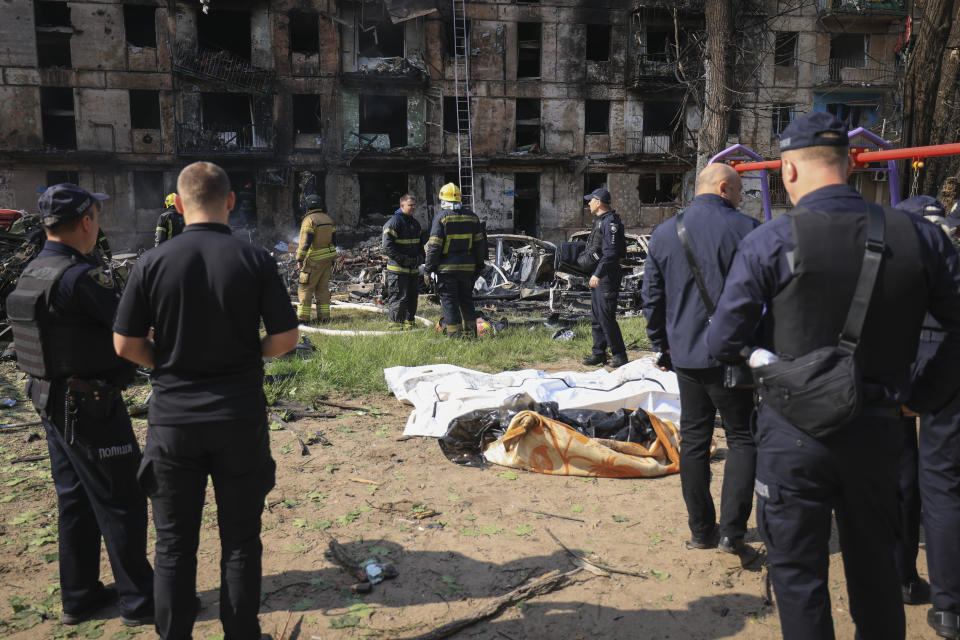 Police stand by dead bodies at the scene of damaged multi-storey apartment building caused by the latest rocket Russian attack in Kryvyi Rih, Ukraine, Tuesday, June 13, 2023. (AP Photo/Andriy Dubchak)