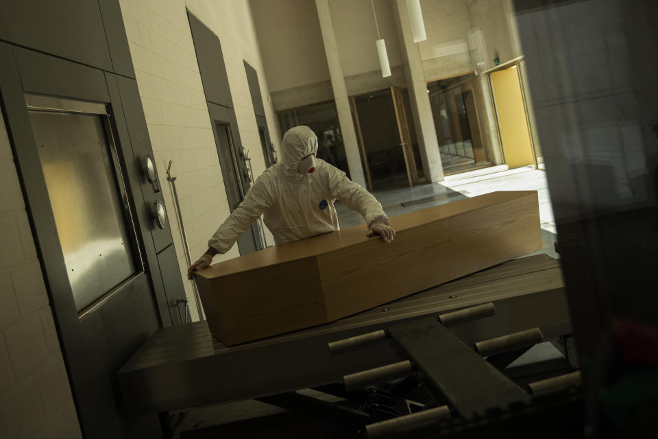 FILE - A worker, wearing full protective gear, moves the casket of a victim of COVID-19 to be cremated during a partial lockdown to prevent the spread of coronavirus at the Pontes crematorium center in Lommel, Belgium, Thursday, April 16, 2020. The World Health Organization is estimating that nearly 15 million people were killed either by the coronavirus or by its impact on overwhelmed health systems in the past two years. That is more than double its official death toll. The U.N. health agency says most of the fatalities were in Southeast Asia, Europe and the Americas. In a report released Thursday, May 5, 2022 WHO chief Tedros Adhanom Ghebreyesus describes the figure as “sobering." (AP Photo/Francisco Seco, File)