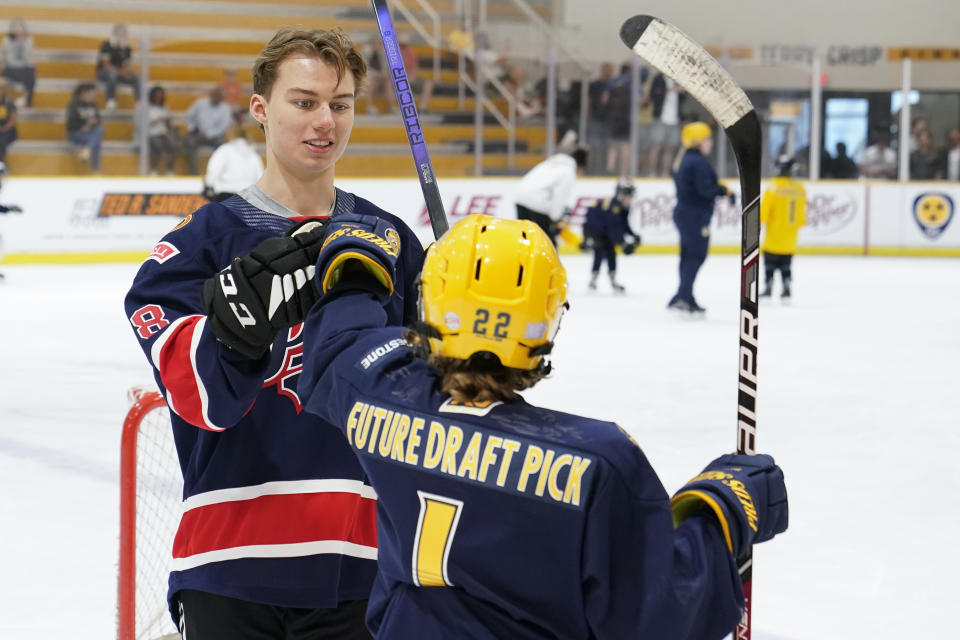 NHL draft prospect Connor Bedard talks with Hayden Spalin during a youth hockey clinic with other draft prospects and members of the NHL Player Inclusion Coalition, Tuesday, June 27, 2023, in Nashville, Tenn. (AP Photo/George Walker IV)