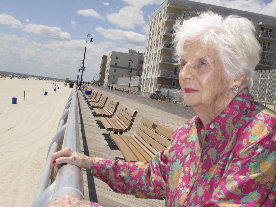 FILE- In this July 22, 2015 file photo, Lucille Horn stands on the boardwalk outside her home in Long Beach, N.Y. Horn who weighed less than two pounds at birth and wasn't expected to survive, lived nearly a century after her parents put their faith in a sideshow doctor at Coney Island who put babies on display in incubators to fund his research to keep them alive. She died in New York at age 96 on Feb. 11, 2017. (AP Photo/Frank Eltman)
