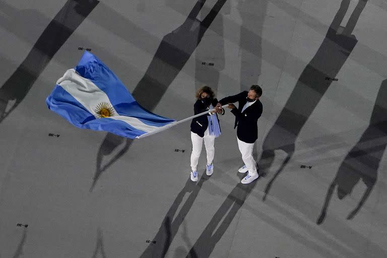 Cecilia Carranza Saroli y Santiago Raul Lange, de Argentina, portan la bandera de su país durante la ceremonia de apertura en el Estadio Olímpico de los Juegos Olímpicos de Verano 2020, el viernes 23 de julio de 2021 en Tokio.