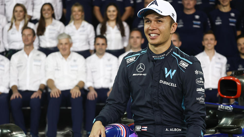 Alex Albon poses in front of the Williams F1 team.