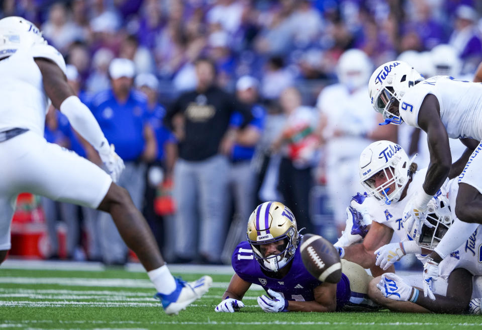 Washington wide receiver Jalen McMillan (11) looks on after fumbling a catch as Tulsa cornerback Reggie Ellis, left, recovers the ball during the first half of an NCAA college football game Saturday, Sept. 9, 2023, in Seattle. (AP Photo/Lindsey Wasson)