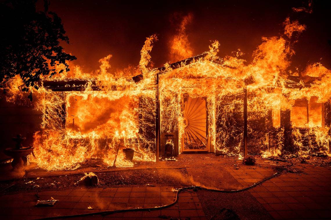 Flames consume a home on Triangle Road as the Oak Fire burns in Mariposa County, Calif., on Saturday, July 23, 2022.