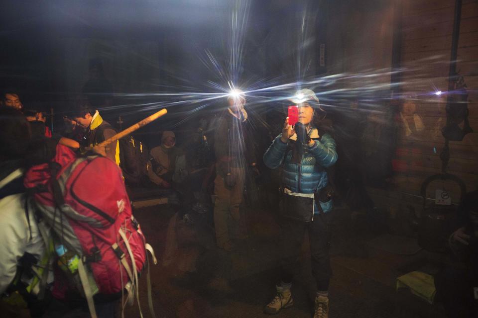 In this Saturday, Aug. 10, 2013 photo, hikers with headlamps stop to take pictures during their climb to the summit of Mount Fuji in Japan before dawn. The Japanese cheered the recent recognition of Mount Fuji as a UNESCO World heritage site, though many worry that the status may worsen the damage to the environment from the tens of thousands who visit the peak each year. (AP Photo/David Guttenfelder)