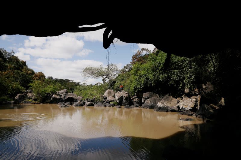 A man stands on a rock overlooking the Munjiriri cave near Nairobi