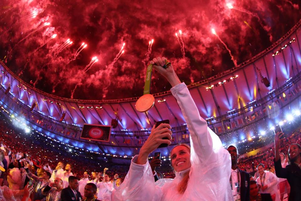 <p>An athlete takes a photo of their medal as fireworks explode near the conclusion of the Closing Ceremony on Day 16 of the Rio 2016 Olympic Games at Maracana Stadium on August 21, 2016 in Rio de Janeiro, Brazil. (Photo by Ezra Shaw/Getty Images) </p>