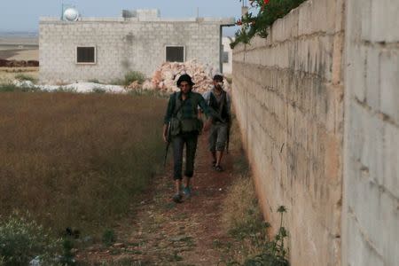 Rebel fighters walk with their weapons after what activists said were clashes with Islamic State fighters in Soran Azaz, Aleppo countryside June 1, 2015. REUTERS/Mahmoud Hebbo