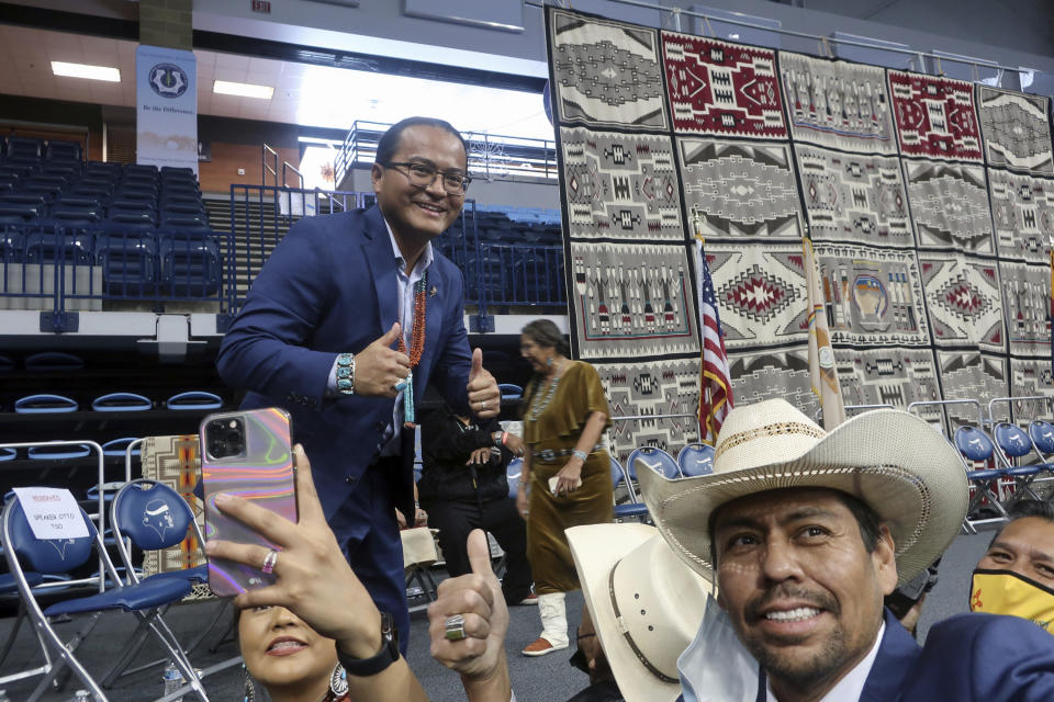 Attendees of the Navajo Nation inauguration take selfies with tribal President Buu Nygren on Tuesday, Jan. 10, 2023, at an indoor sports arena in Fort Defiance, Ariz. Nygren is the youngest person ever elected as Navajo Nation president. His vice president, Richelle Montoya, is the first woman in that position. (AP Photo/Felicia Fonseca)