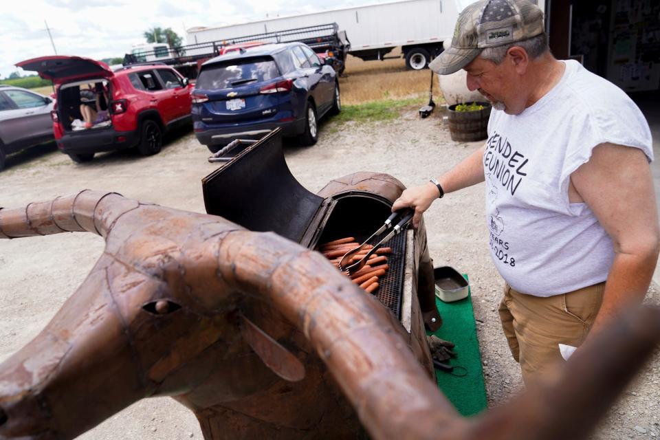Rodney Vershum, 62, of Milan, grills on 'Beaner' the bull during the 115th annual Rendel Family Reunion in Milan on July 30, 2023. Vershum was the host this year and during the event, he was elected to host next year's reunion, as well.