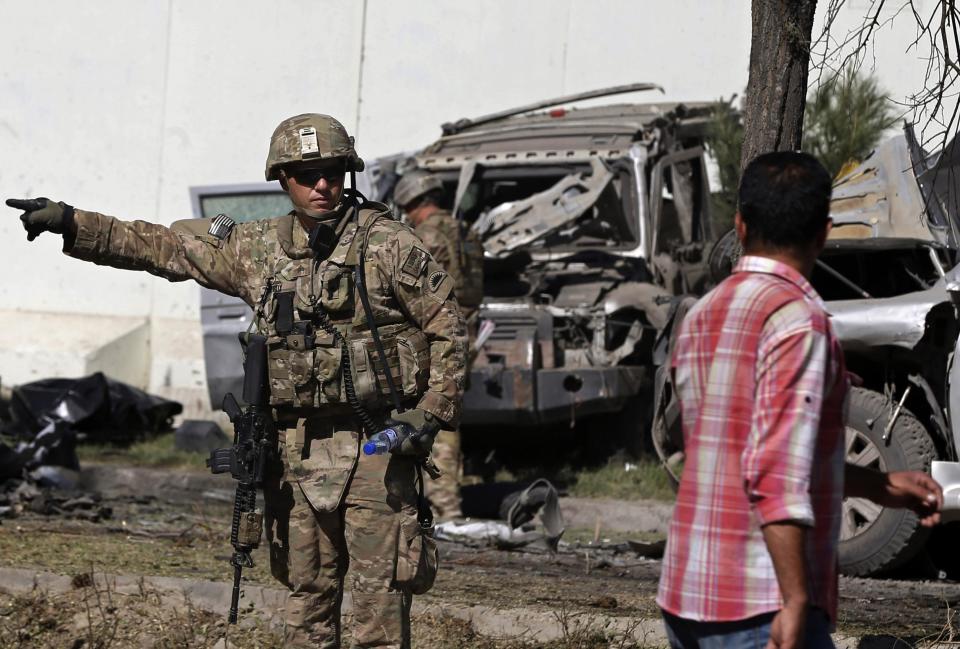 A U.S. soldier prevents locals from approaching the site of a suicide attack in Kabul September 16, 2014. (REUTERS/Omar Sobhani)