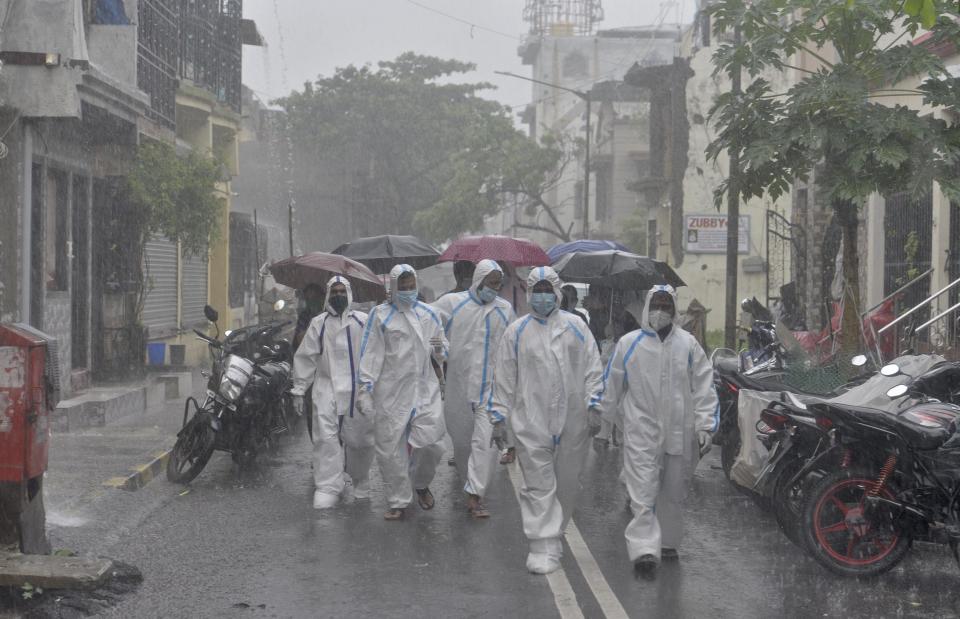 Health care staffs walk on the street of Malvani for the door to door check up at Malad(W) during heavy rain, on July 5, 2020 in Mumbai, India. (Photo by Satyabrata Tripathy/Hindustan Times via Getty Images)