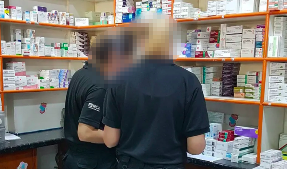 National Crime Agency officers search a pharmacy in south London after a 46-year-old was arrested on suspicion of illegally selling COVID-19 tests. (National Crime Agency)